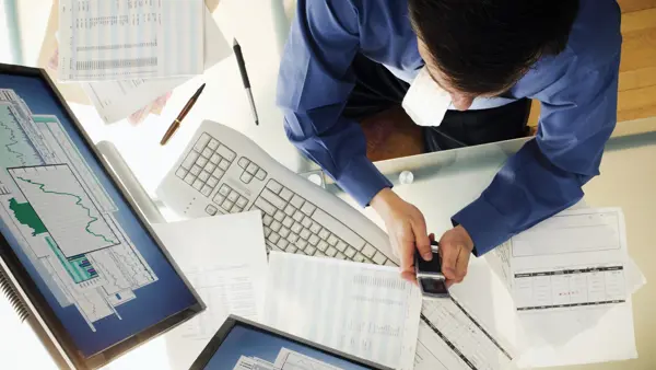 Person working at a desk and using technology Person working at a desk and using technology